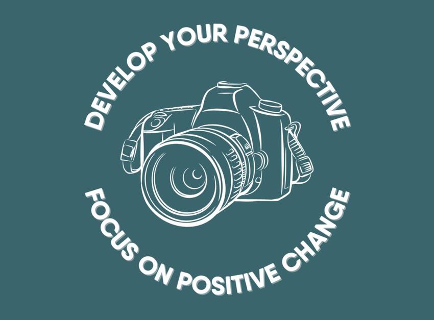 A sketch of a camera with the phrase &quot;develop your perspective, focus on positive change&quot; circling around it.