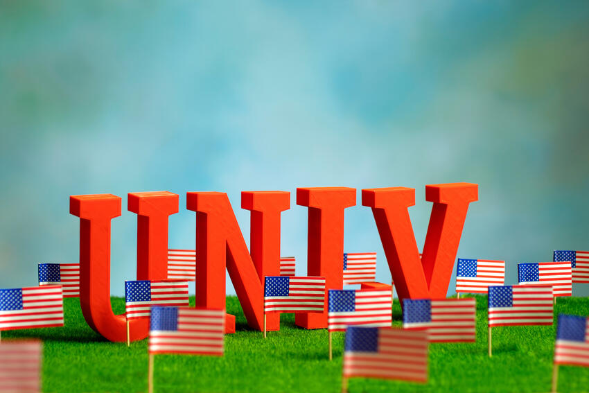 Miniature letters spelling out &quot;UNLV&quot; over a grass landscape with flags of the United States of America