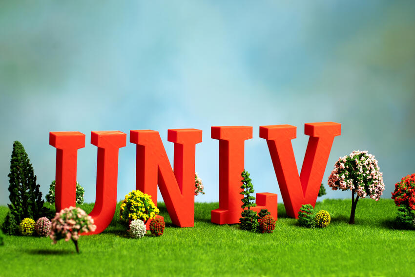 Miniature letters spelling out UNLV over a grass landscape with trees and plants.