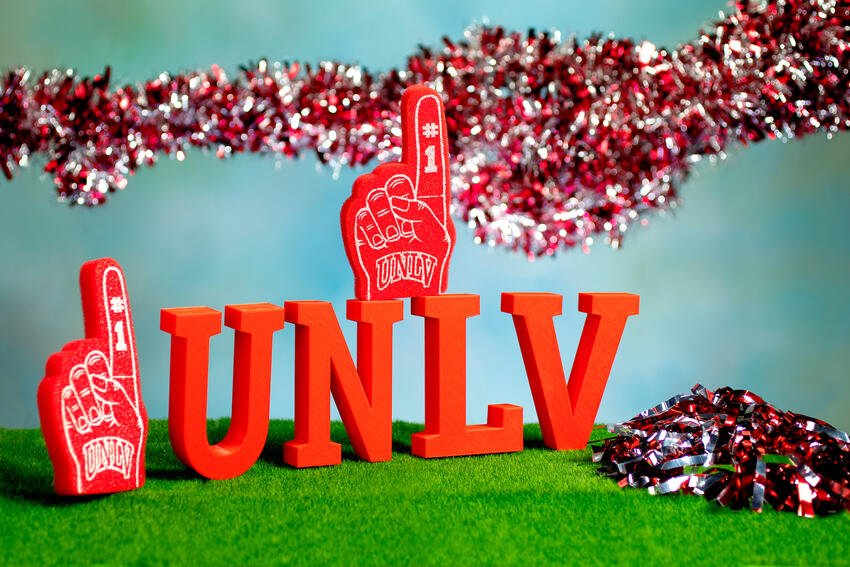 Red U-N-L-V letters with foam fingers and red and white garland decorations