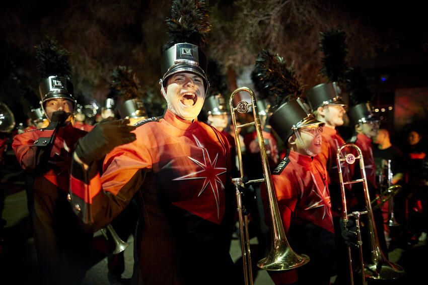 Members of UNLV's marching down performing and cheering during Homecoming Festival.