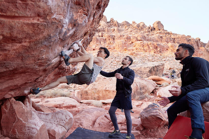 Three students scaling rocks at Red Rock Canyon.