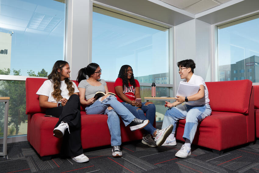 Four students having a conversation on a couch