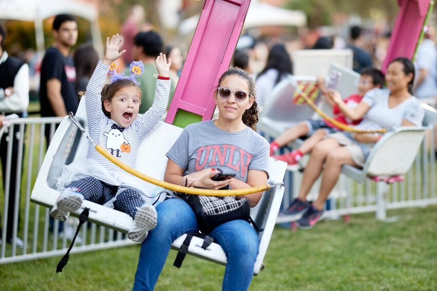 A child and her mom on a carnival ride