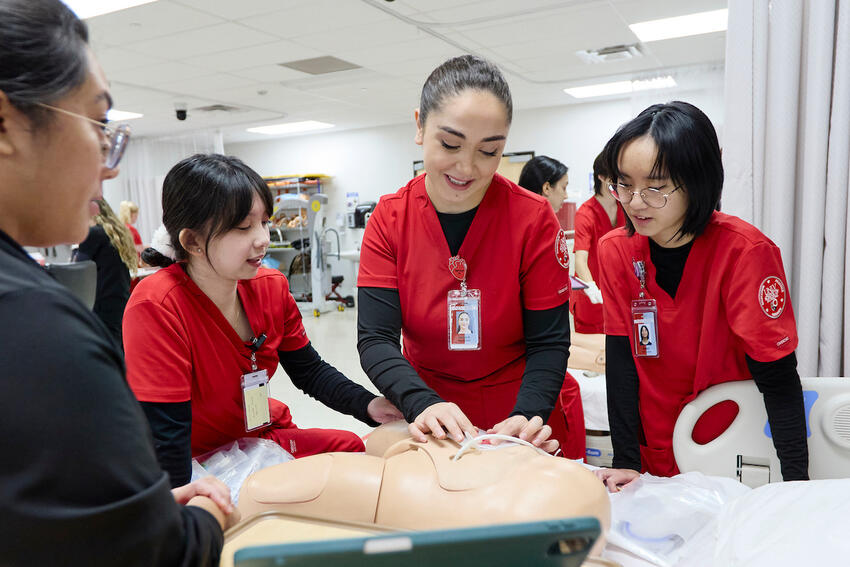 Nursing students practicing on a mannequin in the simulation center