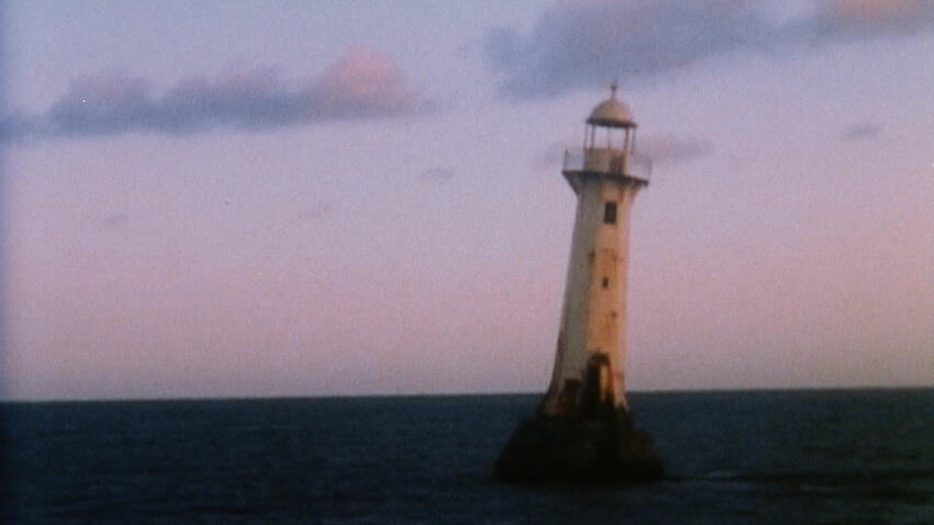 A tilting lighthouse stands on a tiny rocky island in a dark sea. The sky is colored with dim shades of pink and blue.