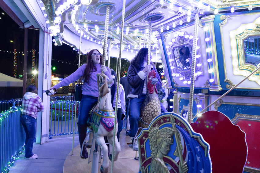 Two women riding on the horse carousel