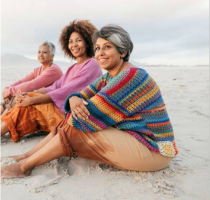 Three women sitting on a beach