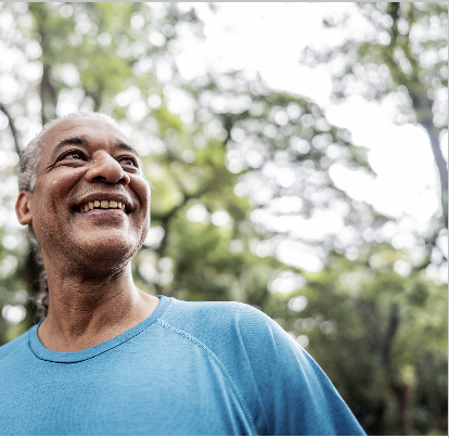 A smiling man outside with trees