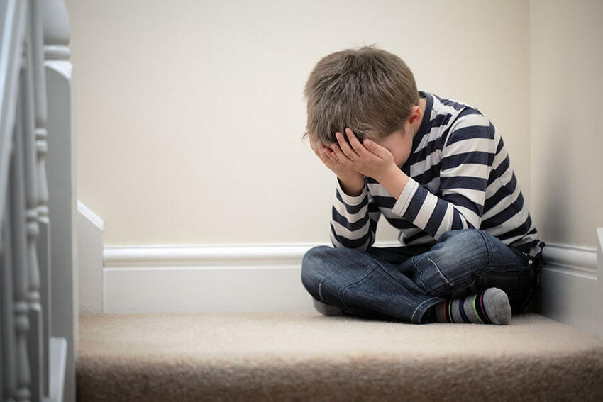 A child sitting with his head in his hands