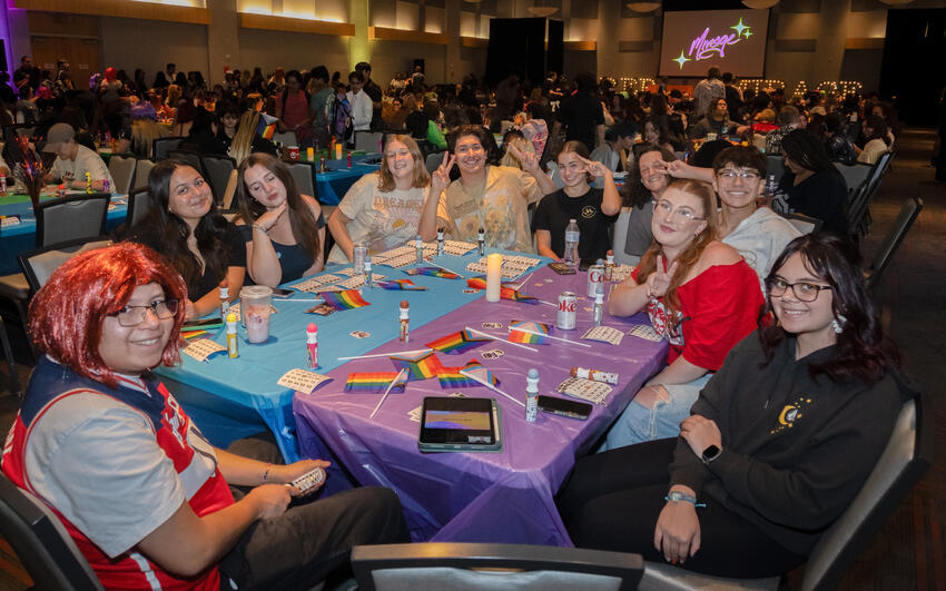 A group of students sitting at a table at drag bingo