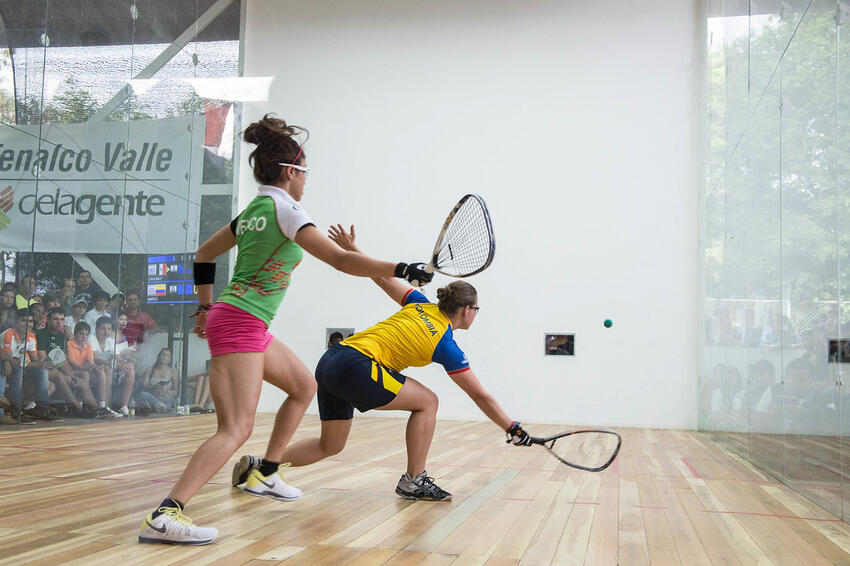 Two raquetball players diving for the ball