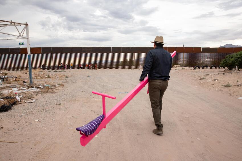 Ronald Rael holding a disassembled pink seesaw