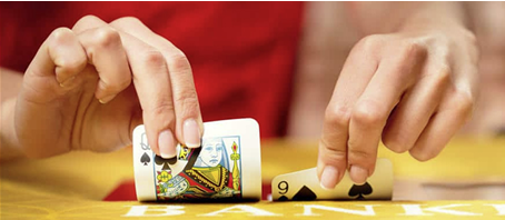 An image of hands holding playing cards