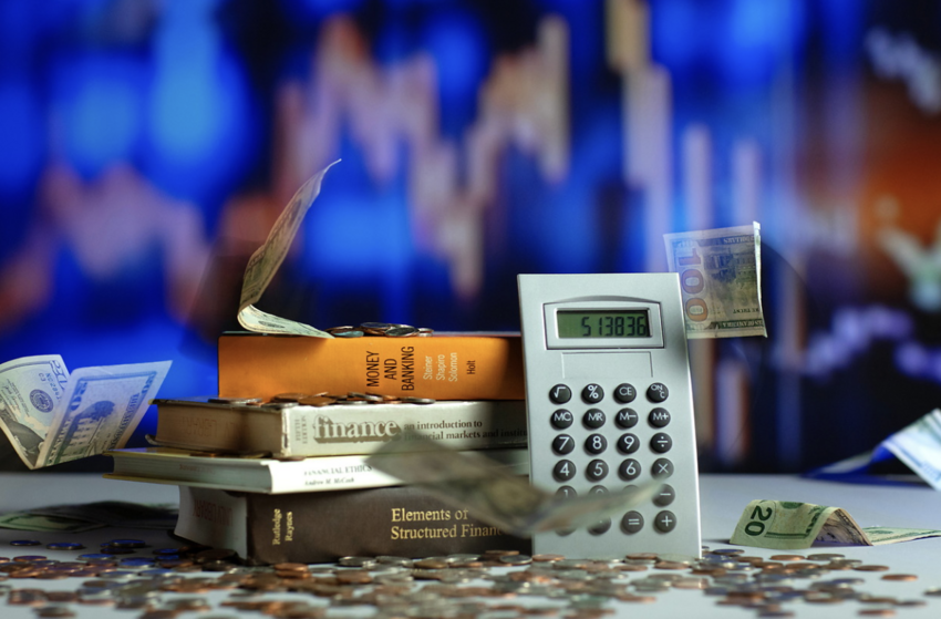 A photo of books, a calculator and money