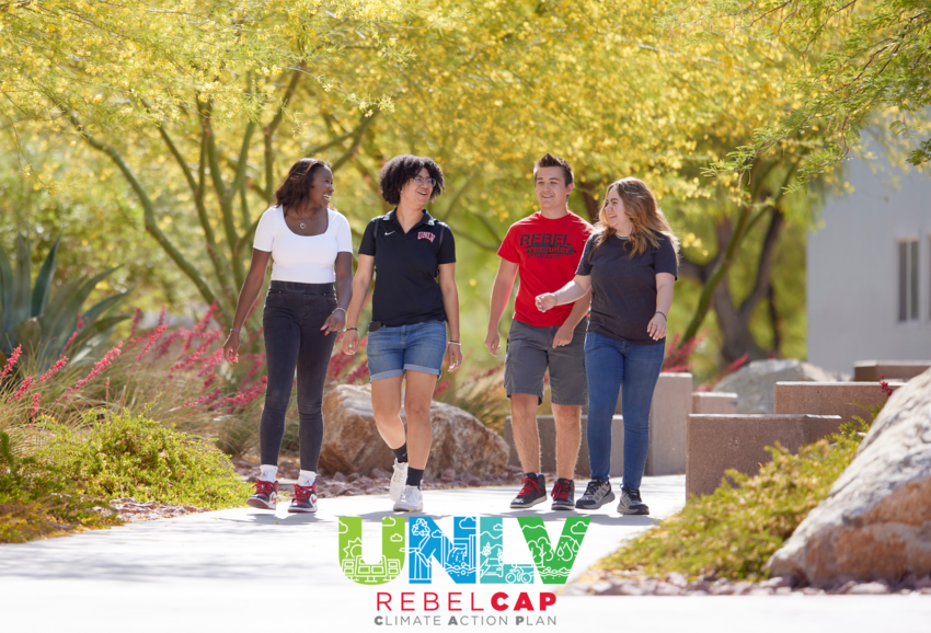 Four UNLV students walking on a sidewalk with trees surrounding them. UNLV Rebel Cap logo is overlaid over the image.