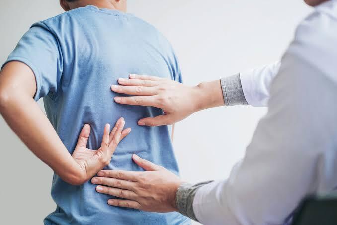 A physician examining a patient's back