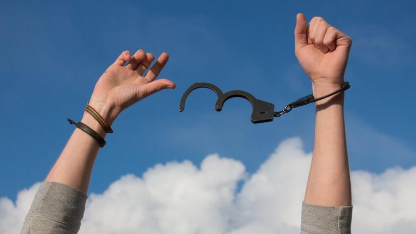 Hands breaking free from handcuffs