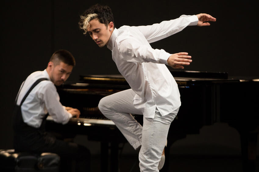 Conrad Tao, on the piano, watches as Caleb Teicher dances.