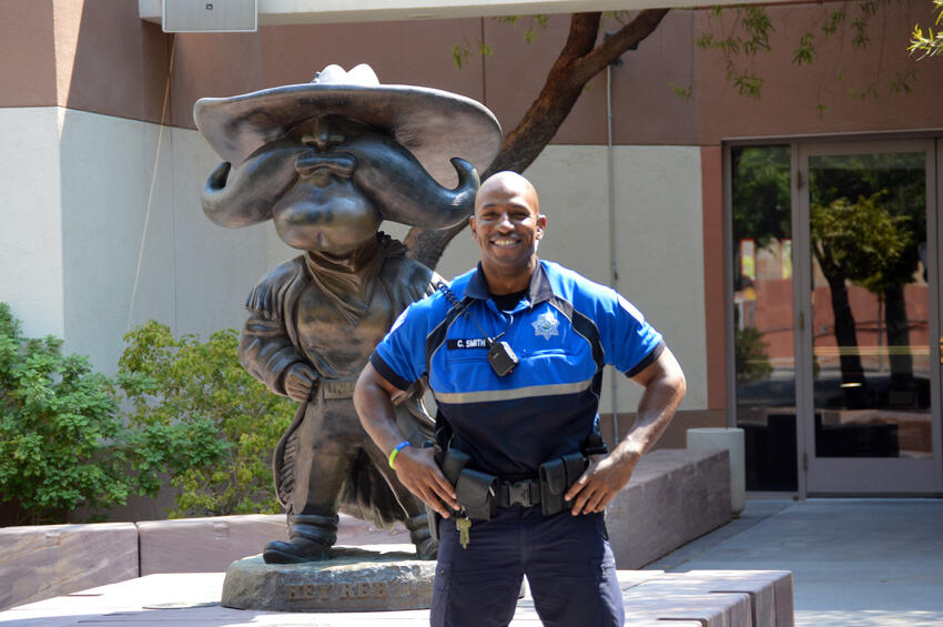 Officer Courtland Smith posing in front of Hey Reb Statute