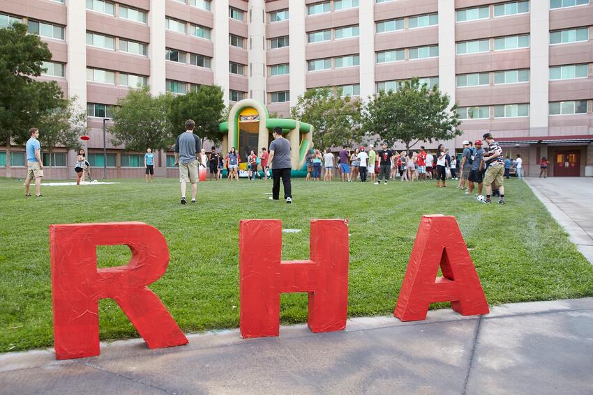 Students hang out on the lawn outside of the Tonopah Residence Complex with giant R.H.A. letters on the lawn