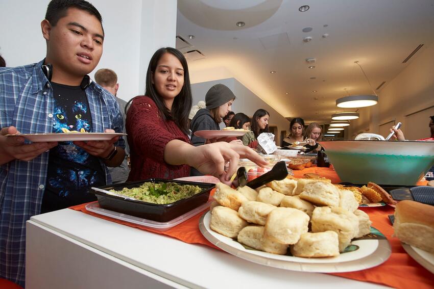 Students serve food on their plates at Thanksgiving dinner