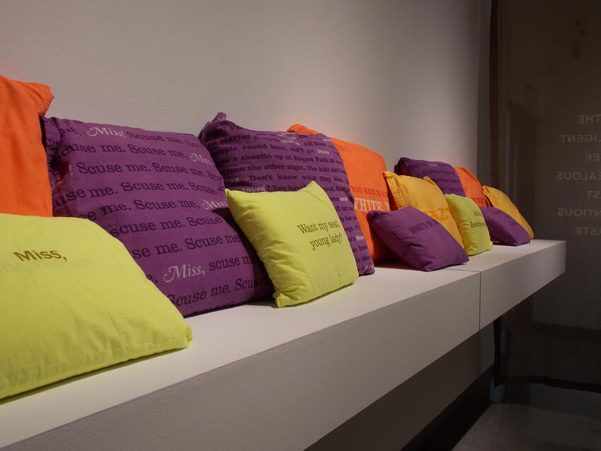 Bench of pillows with messages written on them.