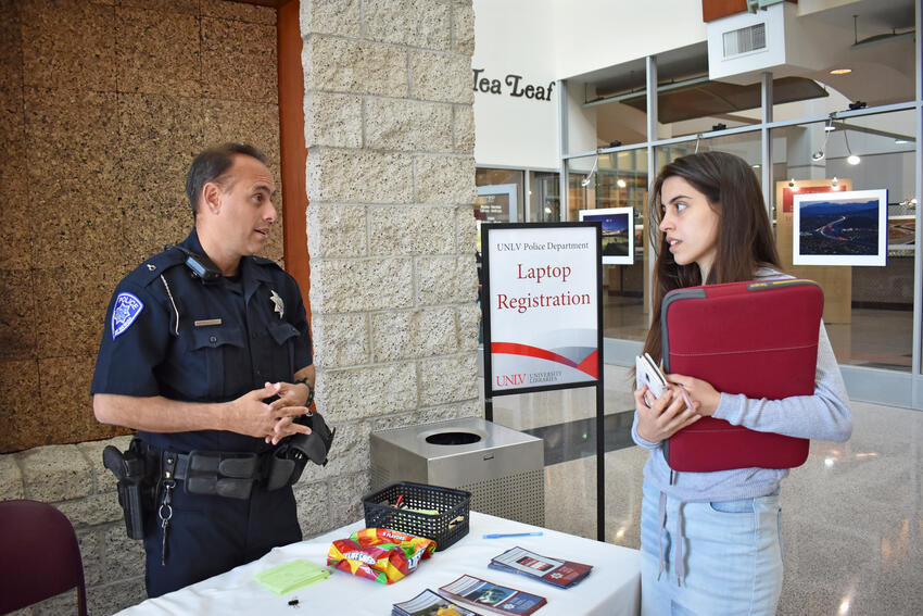 UNLV Police officer helping a student at the property registration table.