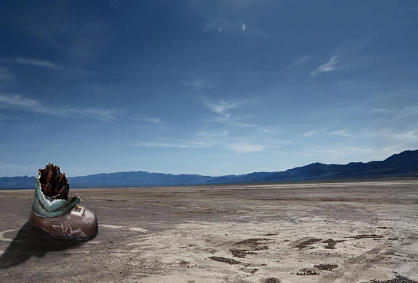 Photo shows a damaged metal object in an expanse of Nevada desert