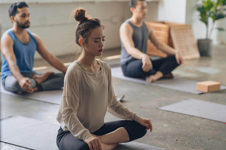 A group of people seating on yoga mats