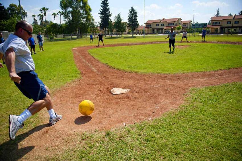 A group of people playing kickball