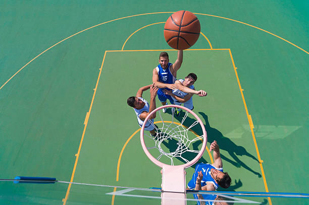 Four men playing basketball