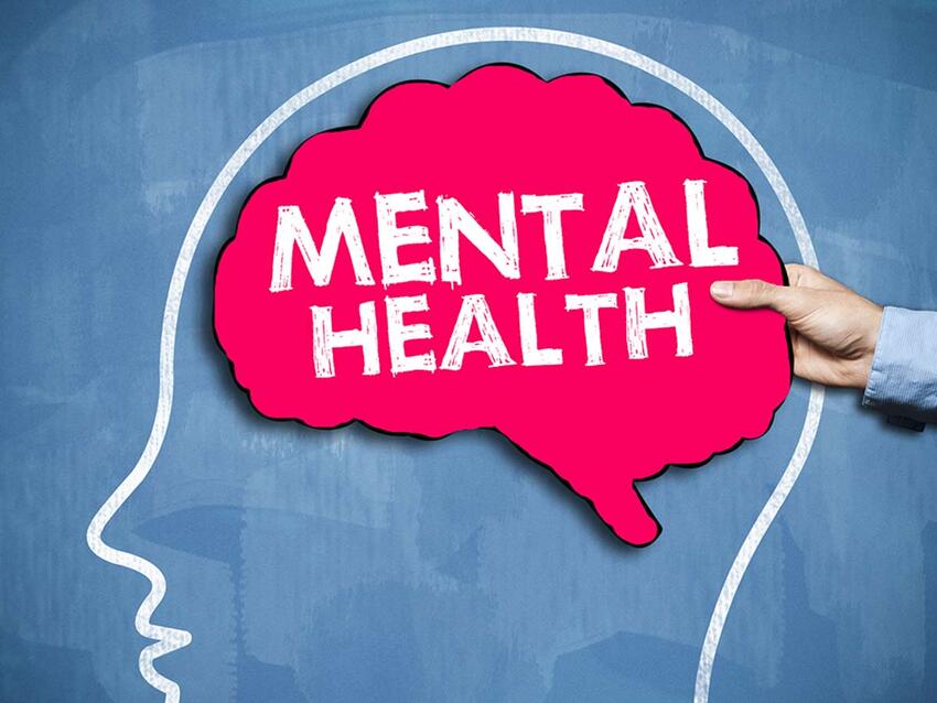 Man holding a brain cutout that says "mental health"