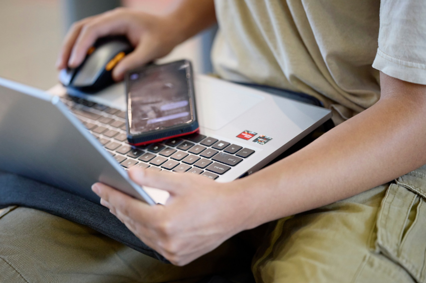 A person on a laptop and phone