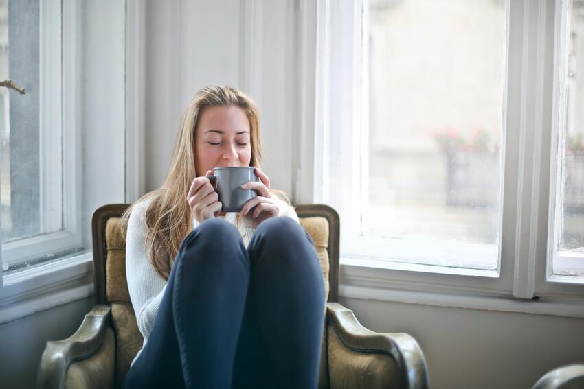 Woman drinking coffee and sitting down.