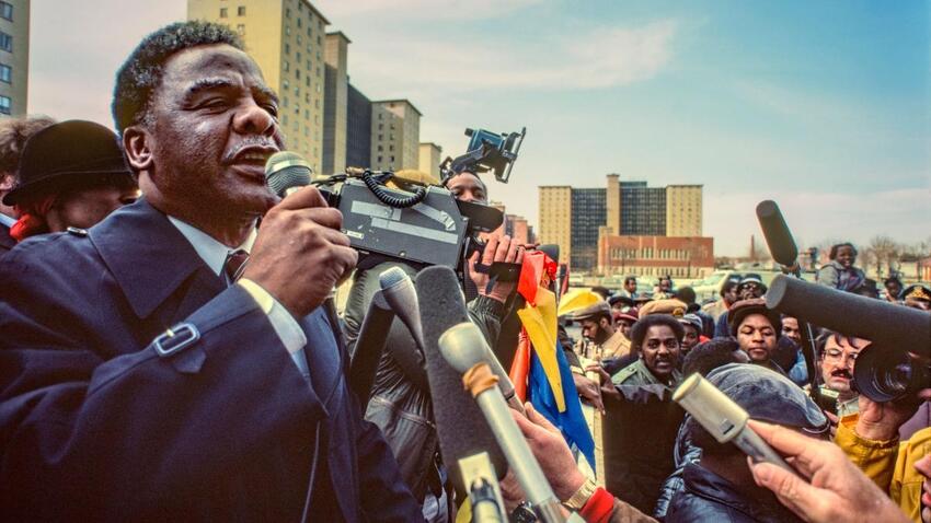 Harold Washington speaking in front of a crowd and cameras.