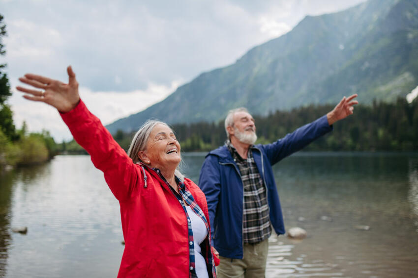 An older couple freely walking by a lake