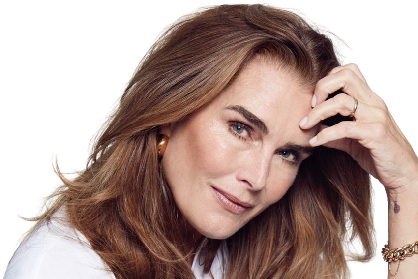 Brooke Shields is resting her head on her palm as she smiles towards the camera in this promotional image.