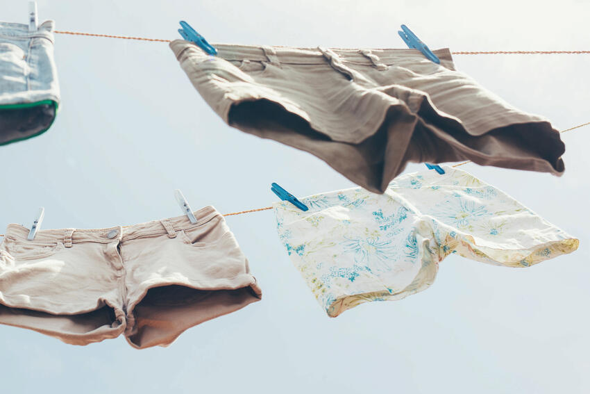 Shorts hang from clotheslines and are blowing in the air in this image.