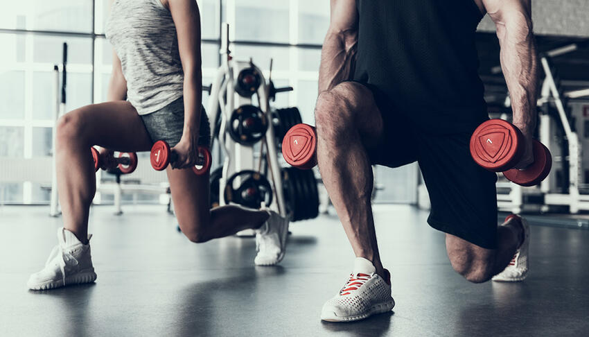 Two men doing weighted front lunges