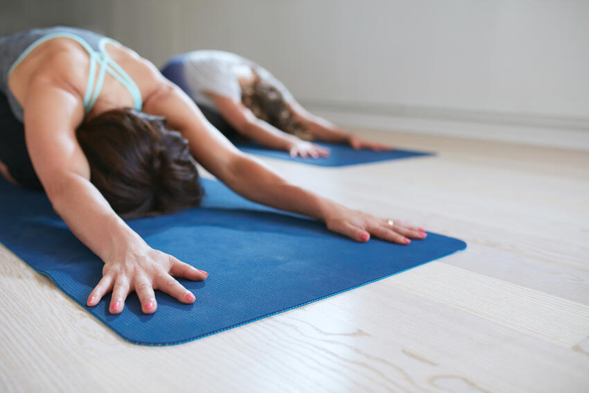 Two people stretching on yoga mats