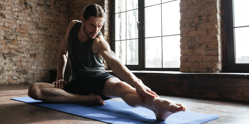 Man performing a yoga stretch on a yoga mat