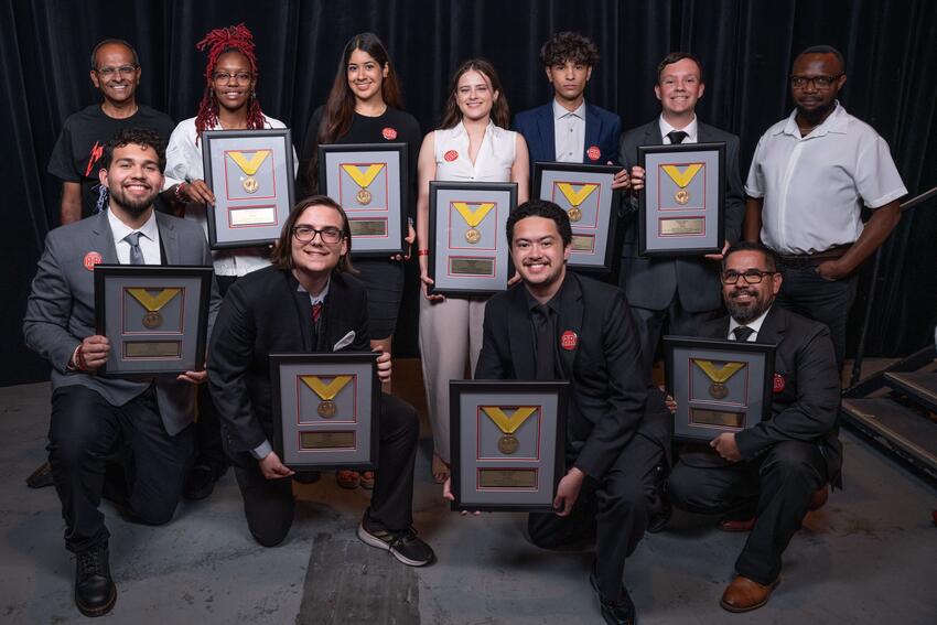 A group of students posing with their senior design award plaques.