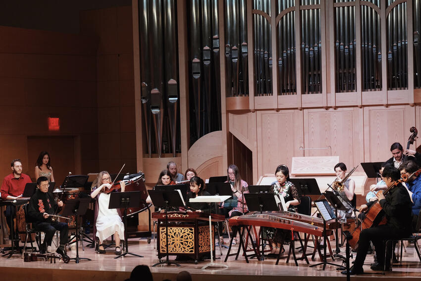 The World Music Chamber Ensemble on stage with their instruments.
