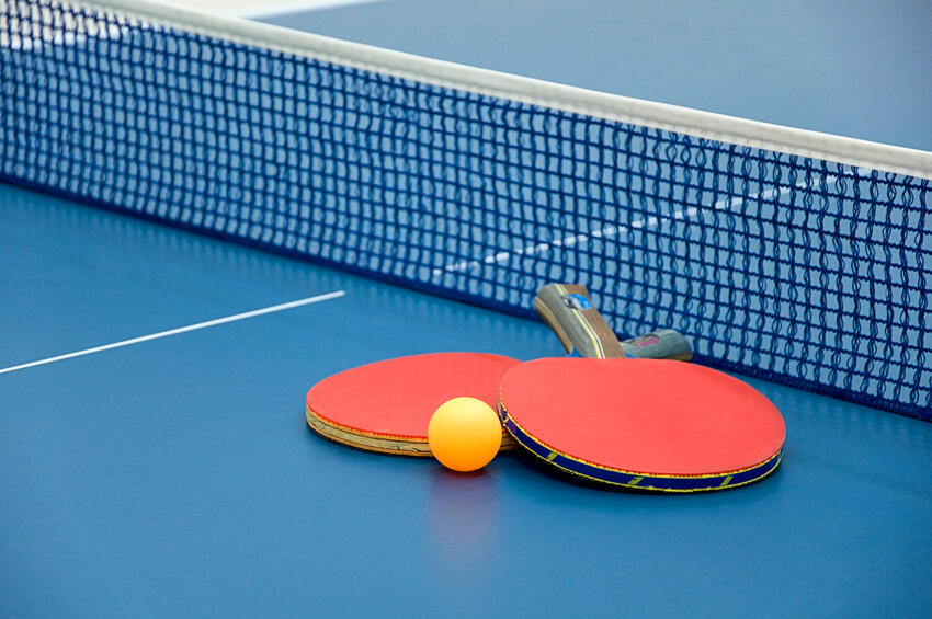 Two table tennis paddles placed on a table tennis court.
