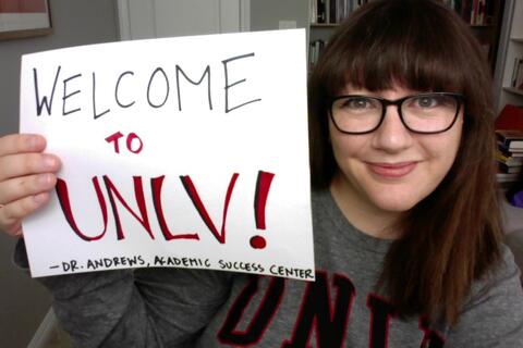 Hanna Andrews holds a sign that says Welcome to UNLV
