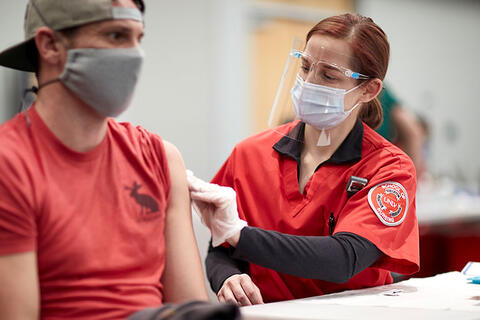 A person getting a vaccination shot from a nurse