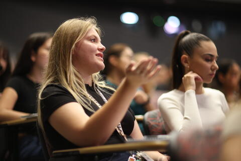 image of students speaking in a lecture hall