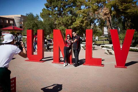 Students pose by large U-N-L-V letters