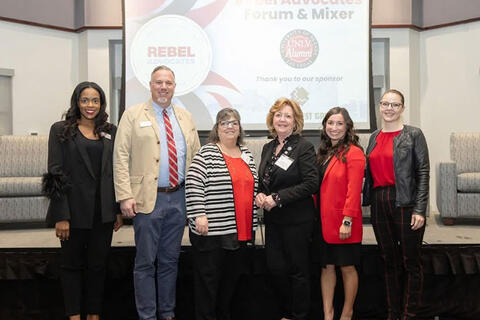 Six people in front of a room
